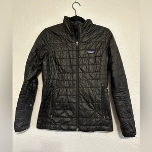 Patagonia women’s nano puff jacket. Black. Size xs. Slight tear in forearm.
